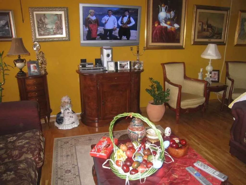 Dnevna soba sa garniturom, TV-om i tradicionalnim namještajem.