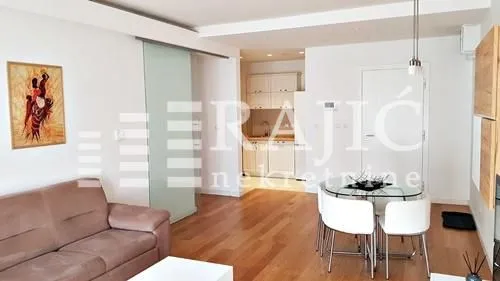 Living room with dining area and view of the kitchen.