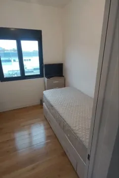 Small bedroom with a bed and a window. - image 11