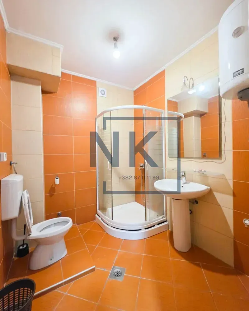 Bathroom equipped with a shower cabin, washbasin, toilet, and water heater.
