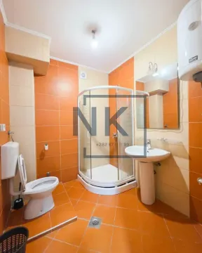 Bathroom equipped with a shower cabin, washbasin, toilet, and water heater. - image 8