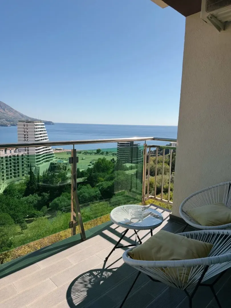 Furnished balcony with seating set and sea view.