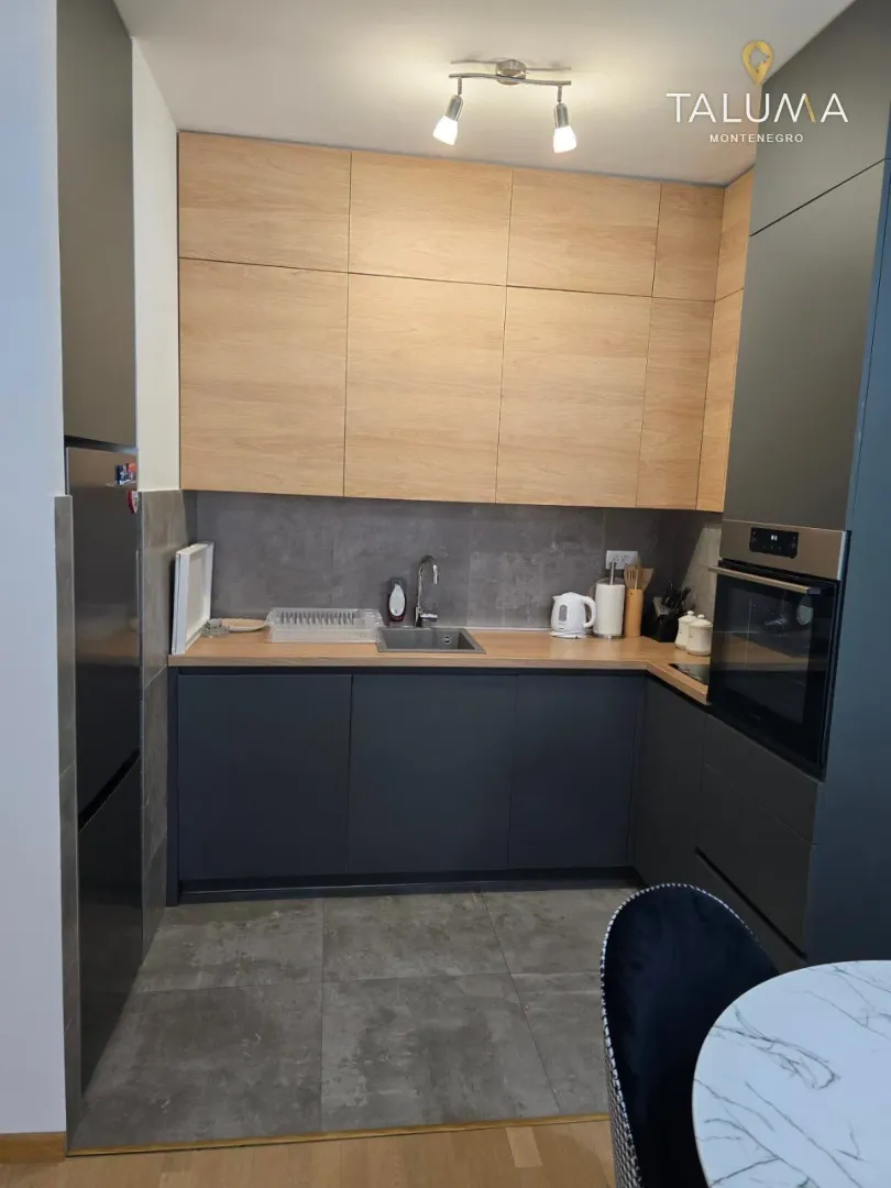 Modern kitchen with wooden upper cabinets and dark lower cabinets.