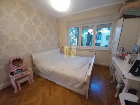 Nameštena spavaća soba sa bračnim krevetom i drvenim podom. - image 8