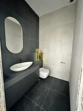 Modernly equipped bathroom with a washbasin, mirror, and toilet. - image 10