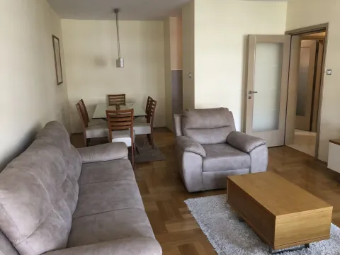 Bright living room with a seating area and a dining table. - image 3