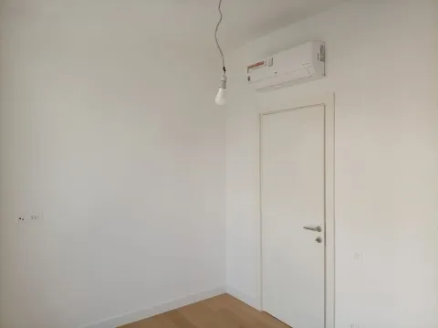 Prazna bijela soba sa drvenim podom, klima-uređajem i vratima. - image 18