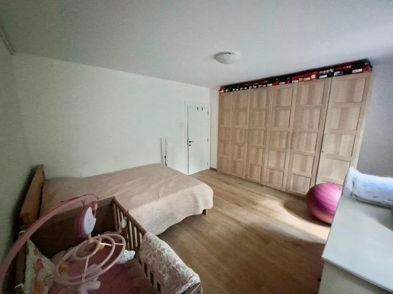 Bedroom with a bed, crib, and a large fitted wardrobe.