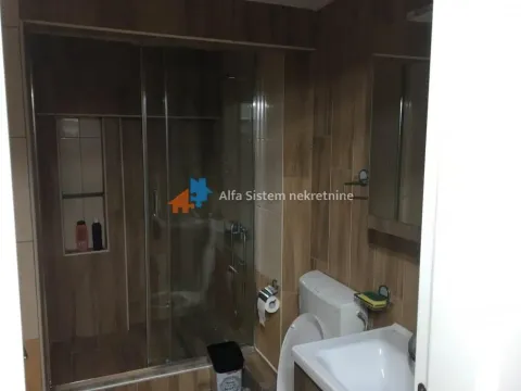 Bathroom tiled in ceramic with a shower cabin, washbasin, and toilet. - image 22