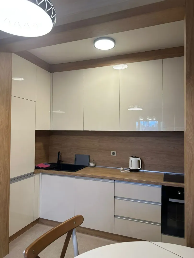 Kitchen with white and wood-finish cabinetry.