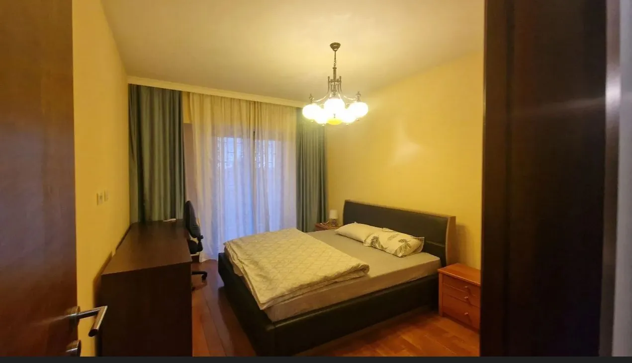 Simply furnished bedroom with a double bed and a desk.