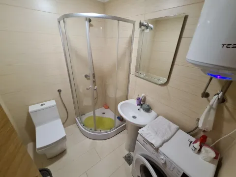Bathroom equipped with a shower cabin, washbasin, toilet, and washing machine. - image 2