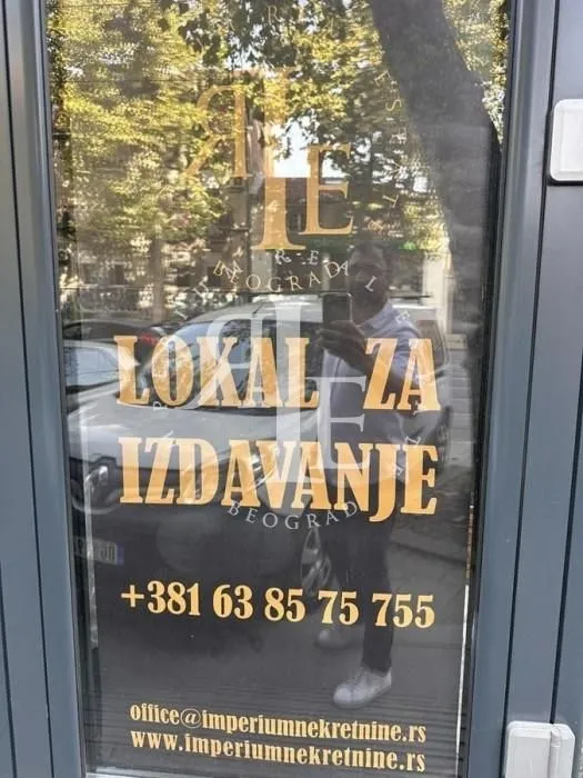 Signage on the commercial space glass with rental information and contact phone number.
