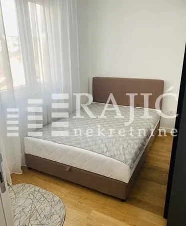 Furnished bedroom with a double bed and a window.
