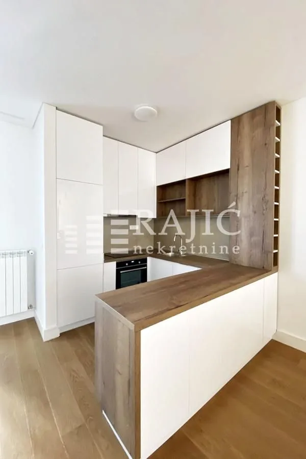 Modern kitchen with white cabinets and wooden details.