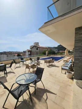 Large terrace with outdoor seating sets and a swimming pool. - image 14