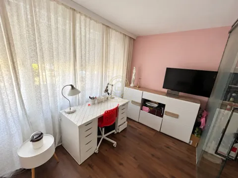 Radni kutak sa pisaćim stolom i televizorom u sobi sa roze zidom. - image 15