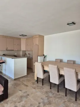 Kitchen with dining area and light-toned cabinetry. - image 10