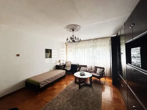 Living room with seating furniture, a desk, and parquet flooring. - image 15