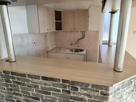 Smaller kitchen with a bar counter and wooden elements. - image 3
