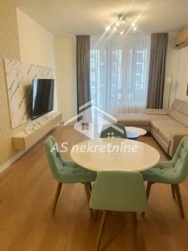 Living room with a dining area, sofa, and television. - image 24