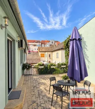Spacious terrace with outdoor seating and a view of surrounding buildings. - image 6