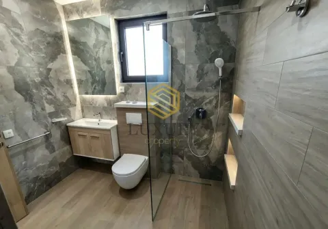 Modernly equipped bathroom with a walk-in shower and marble tiles. - image 9