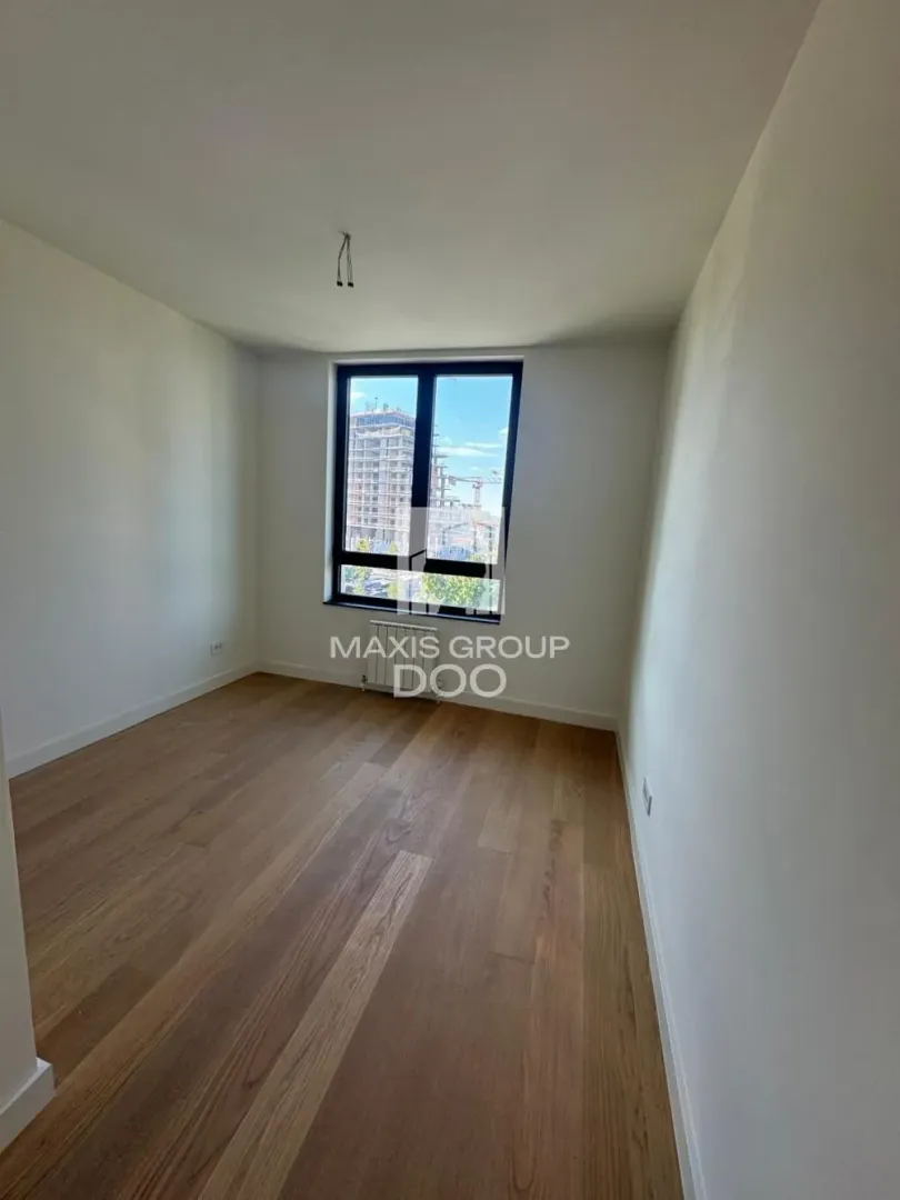 Empty unfurnished room with wooden flooring and a window.