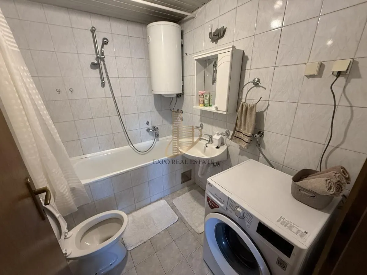Manje kupatilo sa kadom, umivaonikom, wc šoljom i veš mašinom.