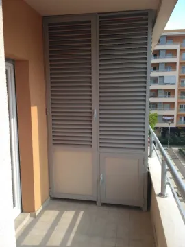 Balkon sa ugrađenim ormarom sa žaluzinama i pogledom na okolne zgrade. - image 4