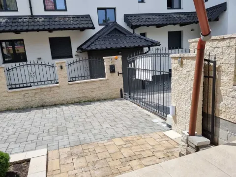 Dvorište sa popločanim parkingom i kovanom ogradom ispred kuće. - image 16