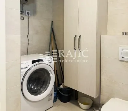 Small bathroom with a washing machine and a cabinet. - image 10