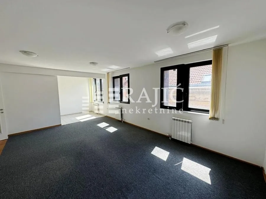 Empty spacious room with carpet and windows.