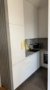 Moderna bela kuhinja sa ugrađenim elementima i tamnim podom. - image 5