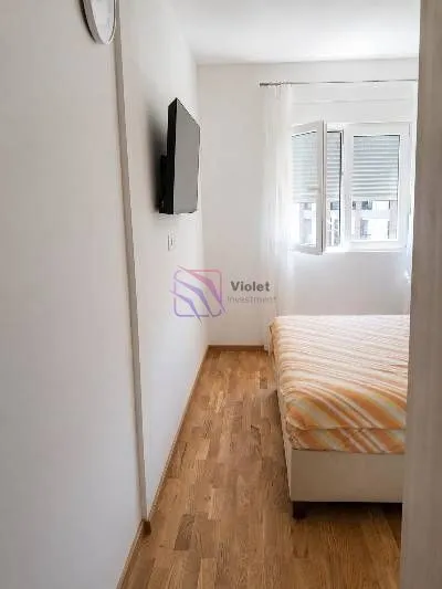 Smaller bedroom with a bed and a wall-mounted TV.