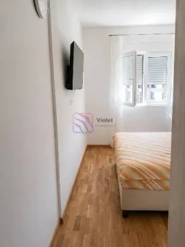 Smaller bedroom with a bed and a wall-mounted TV. - image 5