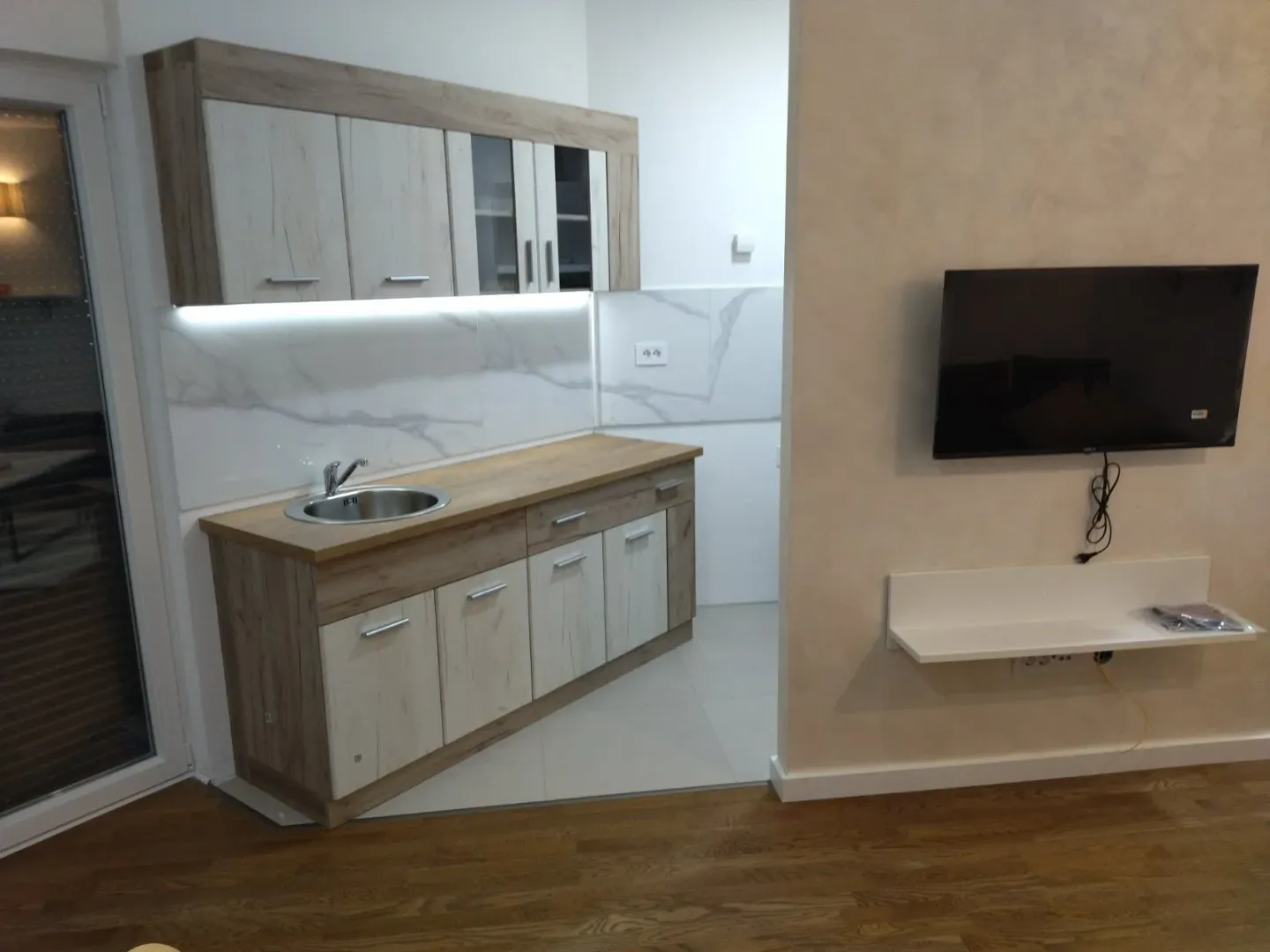 Small modern kitchen with wooden elements and built-in sink.
