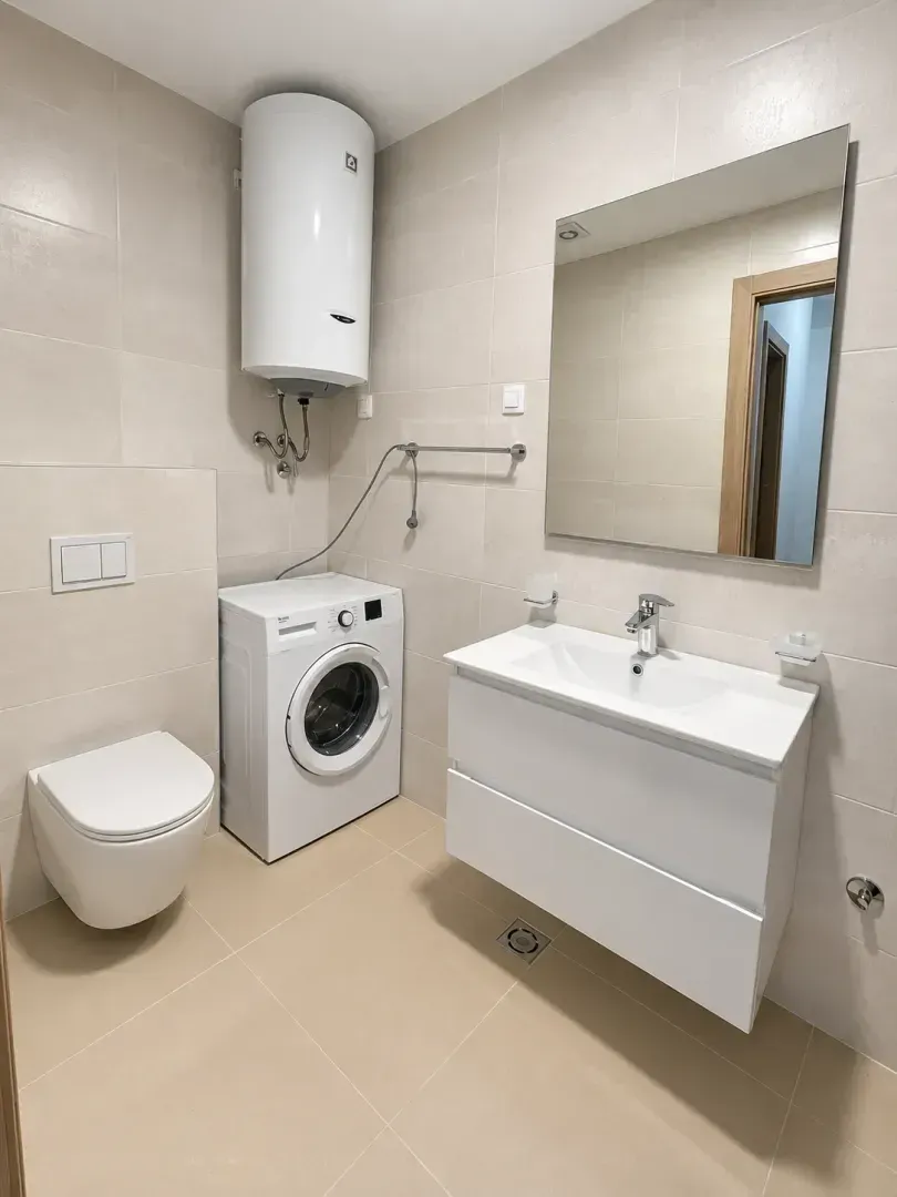Moderne kupatilo sa sanitarijama, umivaonikom i veš mašinom.