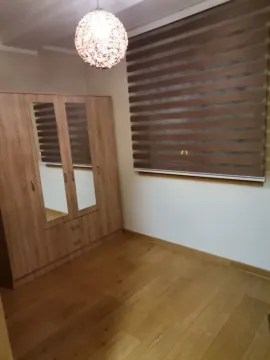 Small room with a wooden wardrobe, parquet flooring, and window blinds. - image 6