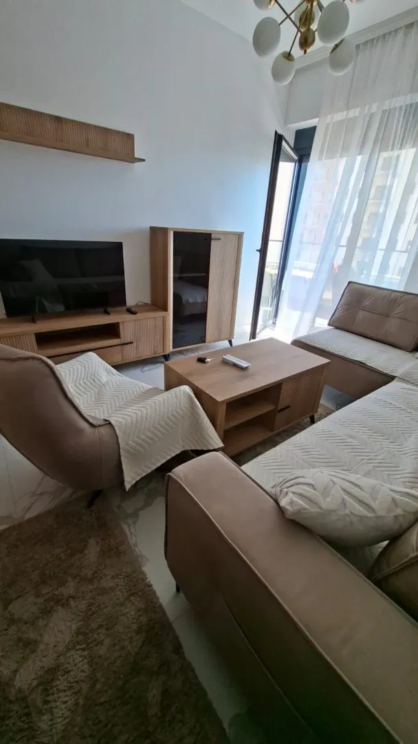 Living room with sofa set, coffee table, and TV unit.