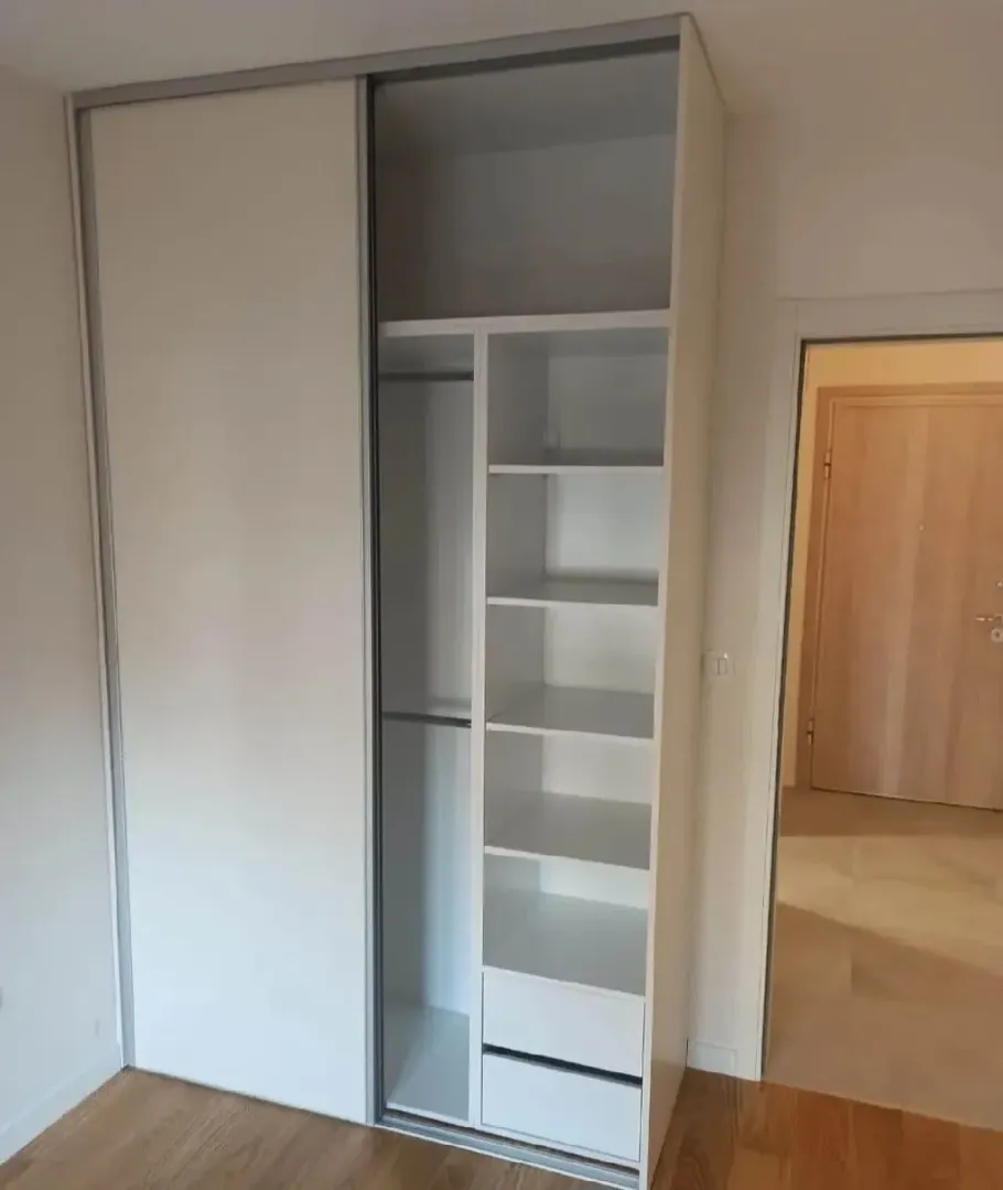 Built-in wardrobe in the bedroom with shelving and hanging space.