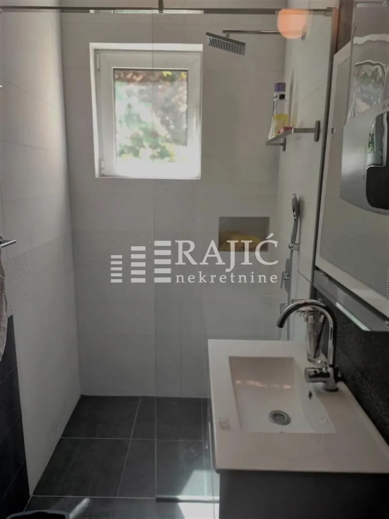 Modern bathroom equipped with a sink and a shower cabin.