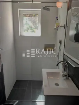 Modern bathroom equipped with a sink and a shower cabin. - image 12