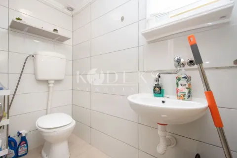 Bathroom equipped with a toilet bowl, washbasin, and white wall tiles. - image 3