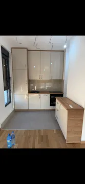 Small modern kitchen with beige cabinets and wood details. - image 4