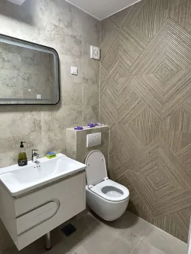 Modern bathroom featuring a sink, mirror, and decorative tiled wall. - image 14