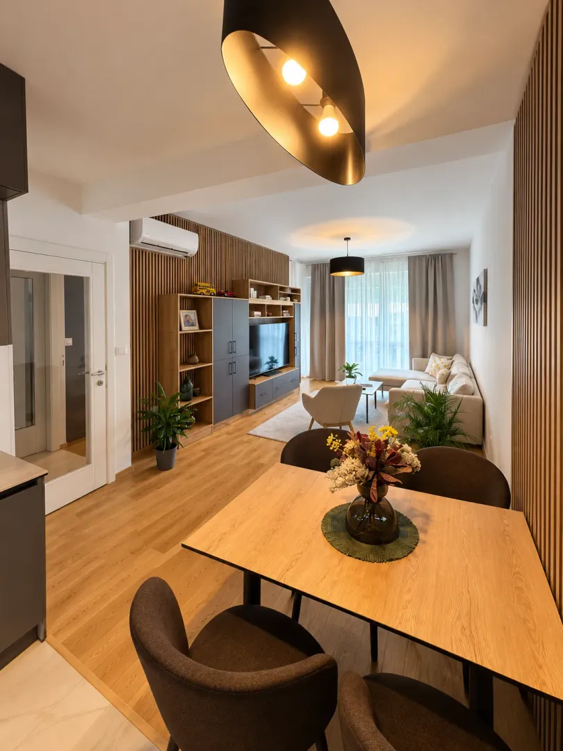 Living room with a dining area and modern wooden wall paneling.