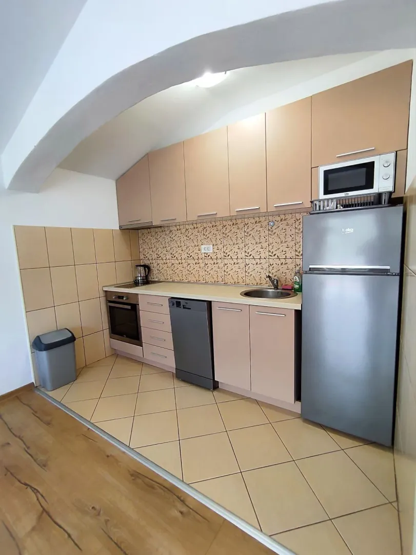 Small kitchen with beige cabinetry and built-in appliances.