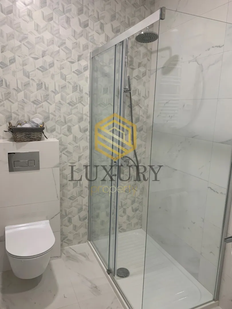 Modernly equipped bathroom with a walk-in shower and built-in toilet.