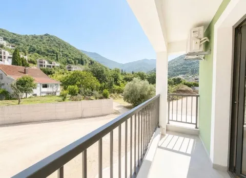 Natkriveni balkon sa metalnom ogradom i pogledom na brda i okolinu. - image 3